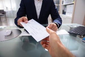 handing check to someone at a desk