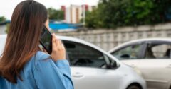 Woman drivers call insurance after a car accident before taking pictures and sending insurance