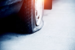 Close up of a flat tire on an old car.