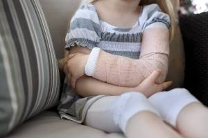 girl holding broken arm