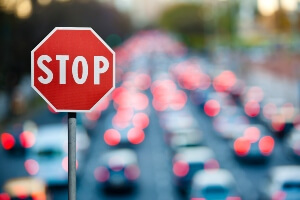 close-up of a stop sign with traffic blurred in the background