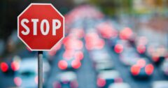 close-up of a stop sign with traffic blurred in the background